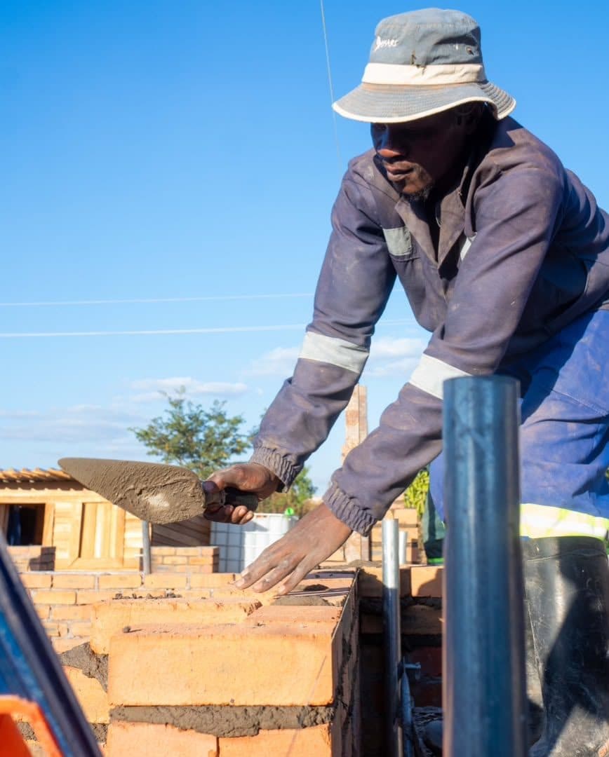 Bricklayer setting a course by hand