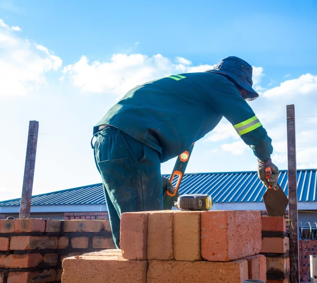 Bricklayer checking a corner with a spirit level